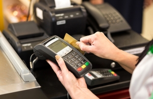 Woman hand with credit card swipe through terminal for sale, in